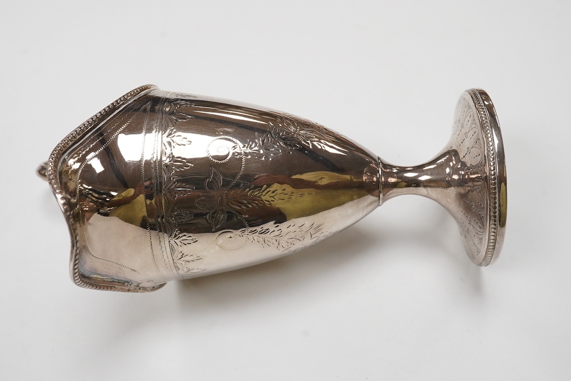 A George III engraved silver helmet shaped cream jug, Henry Chawner, London 1788(repair), height 15.3cm, together with two George V silver toast racks, a silver mounted glass toilet jar and a modern silver mounted bottle